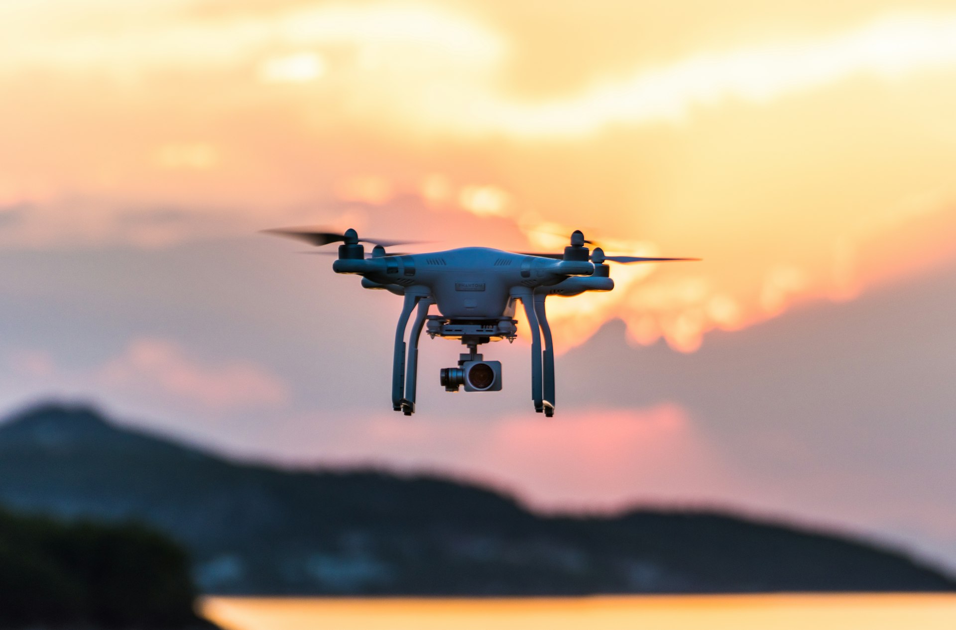 Drone caméra en vol au coucher du soleil, ciel doré au-dessus des collines